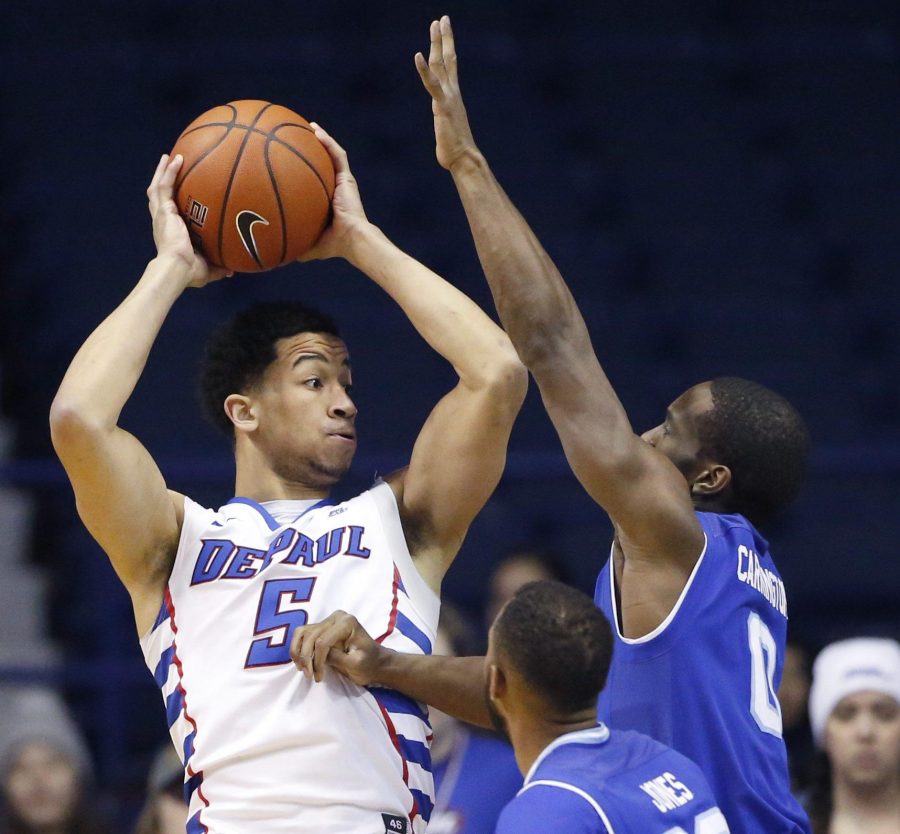DePaul guard Billy Garrett Jr., left, looks to pass as Seton Hall guard Khadeen Carrington (0) and guard Madison Jones (30) guard during the first half of an NCAA college basketball game Saturday, Feb. 25, 2017, in Rosemont, Ill. (AP Photo/Nam Y. Huh)