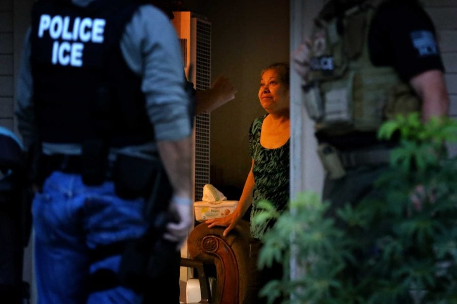 ICE Enforcement and Removal Operations officers, in search of 32-year-old Hugo Medina, question his mother Magdalena Medina, 69, about his whereabout in a morning raid on his residence on Aug. 12, 2015 in Riverside, Calif. (Irfan Khan/Los Angeles Times/TNS)
