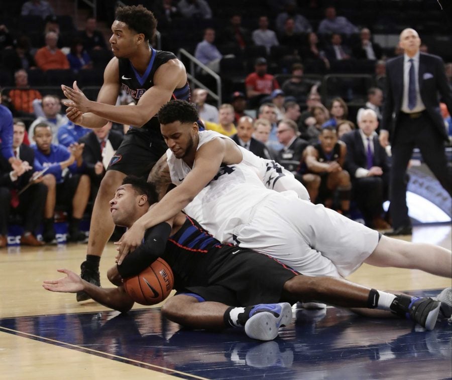 Xavier's Trevon Bluiett, above, and DePaul's R.J. Curington, bottom, scrap for the ball as DePaul's Eli Cain, left, calls for a time out during the first half of an NCAA college basketball game in the Big East men's tournament Wednesday, March 8, 2017, in New York. (AP Photo/Frank Franklin II)