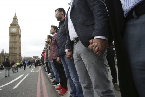 People link their hands during a commemorative event to mark last week's attack outside Parliament that killed four people, on Westminster Bridge in London, Wednesday, March 29, 2017. (Yui Mok/PA via AP)