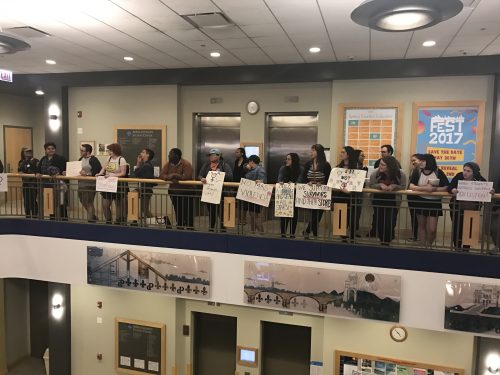Demonstrators filed into the Student Center holding signs and repeating chants before circling up around the atrium on Thursday. 