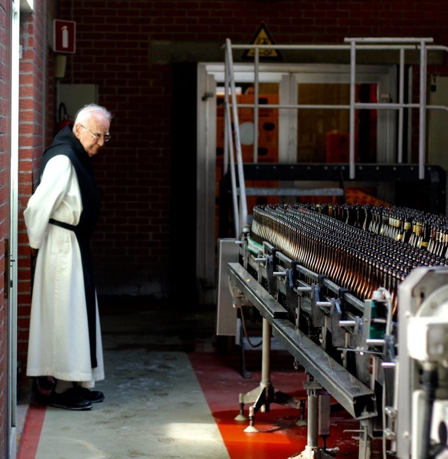 A Trappist monastery employee examines the bottling line at the Rochefort Brewery in Rochefort, Belgium. 
(Photo Courtesy of Shiffer Publishing, LTD)
