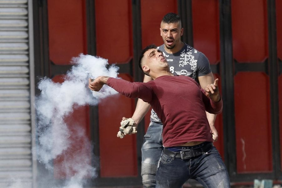 A Palestinian man hurls a tear gas grenade back at Israeli police forces in a clash on the Gaza Strip.
(Photo courtesy of the Associated Press)