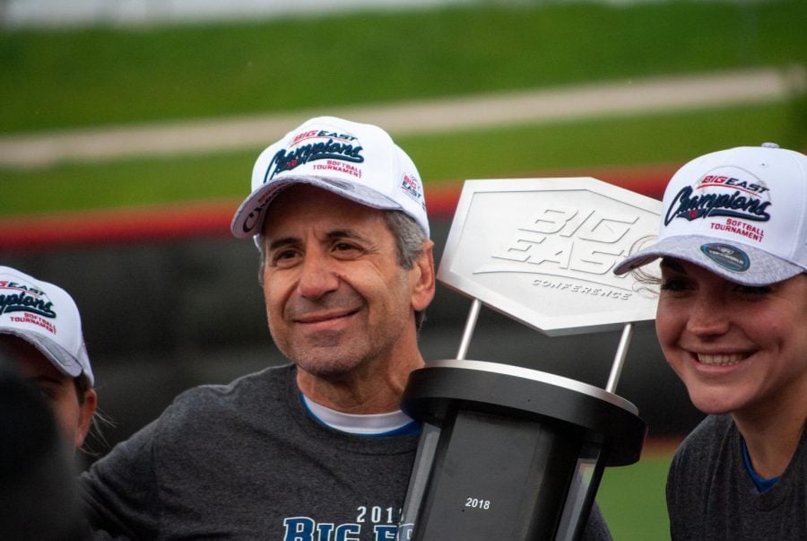 Head Coach Eugene Lenti holds the Big Easr Conference title trophy.