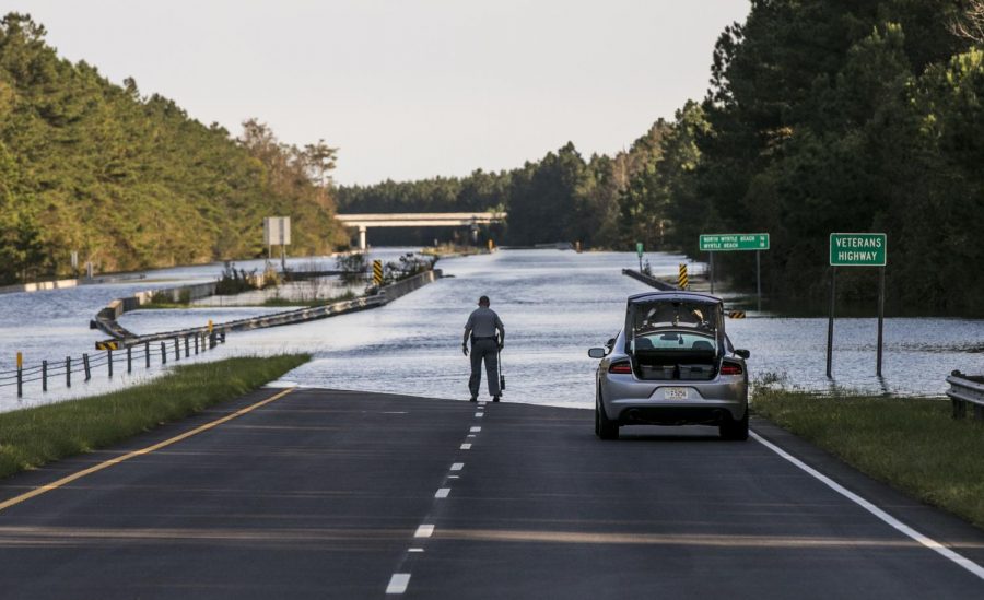 S.C. Highway 22 is flooded between SC-90 and SC-905 on Saturday, Sept. 22, 2018, in Conway, S.C. An officer with the South Carolina State Highway Patrol marks the water level to compare against previous days. The blocked road has traffic snarled around Conway and the Waccamaw River continues to rise past record levels.