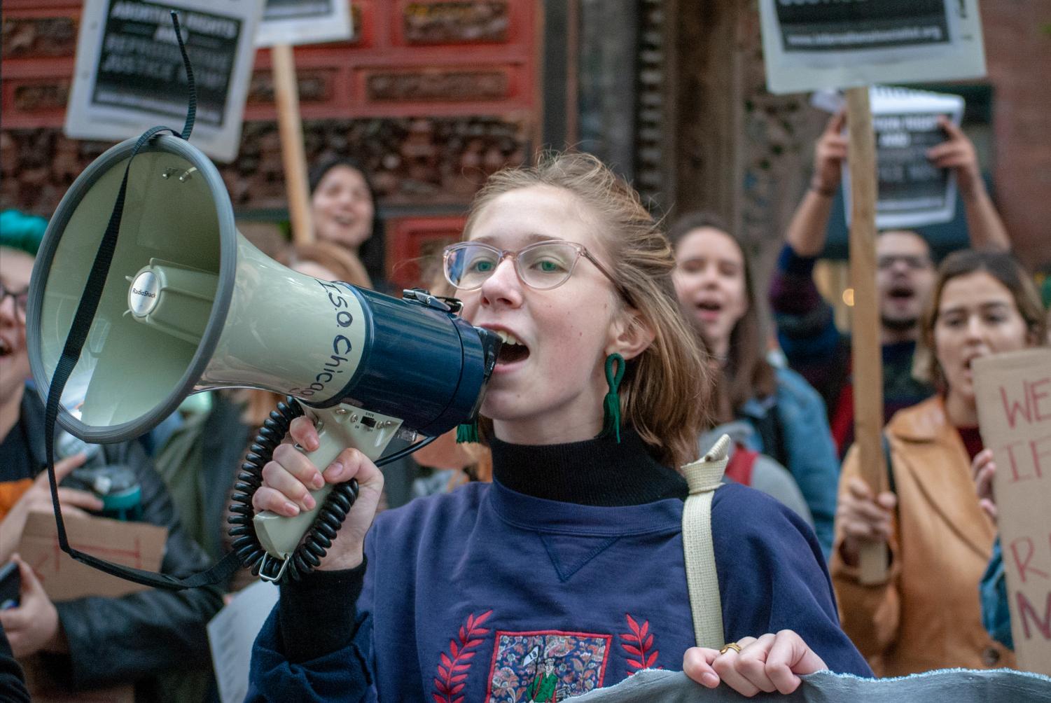 Holding onto a megaphone, a protester stands outside the American Bar Association Chicago in opposition of the nomination of Judge Brett Kavanaugh following sexual assault claims.