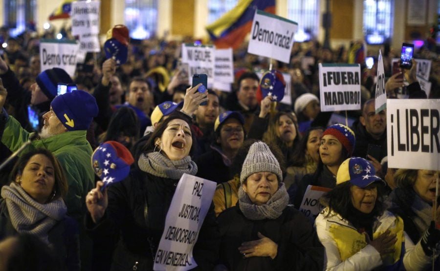 In this Wednesday, Jan. 23, 2019  le photo, people gather during a protest against Venezuelas Nicolas Maduro and in support of an opposition leader self-proclaimed as the interim president of the country in Madrid, Spain.