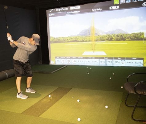 DePaul senior Bobby Thomas practices hitting his wedge to a variety of distances as part of a friendly contest with his teammates. 