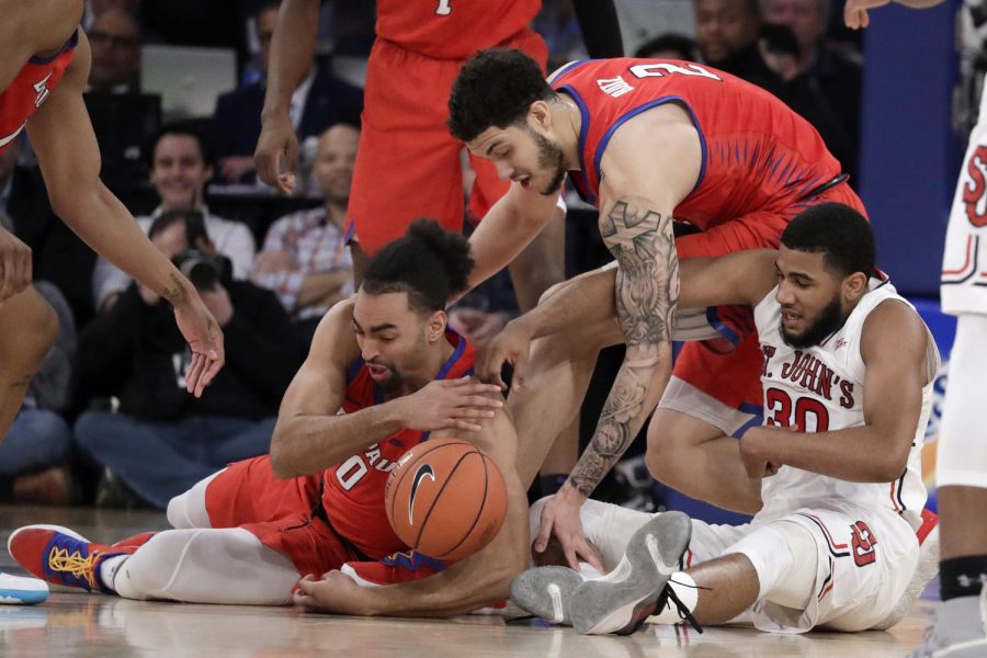 DePaul guard Lyrik Shreiner and sophomore forward Jaylen Butz scramble for a loose ball with St. John's guard LJ Figueroa during the second half of DePaul's Big East Tournament loss to the Red Storm. Julio Cortez | AP 