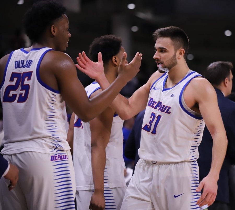 Seniors Femi Olujobi (left) and Max Strus (right) share a high five at the end of DePauls senior day victory over St. Johns at Wintrust Arena Sunday afternoon. Alexa Sandler | The DePaulia