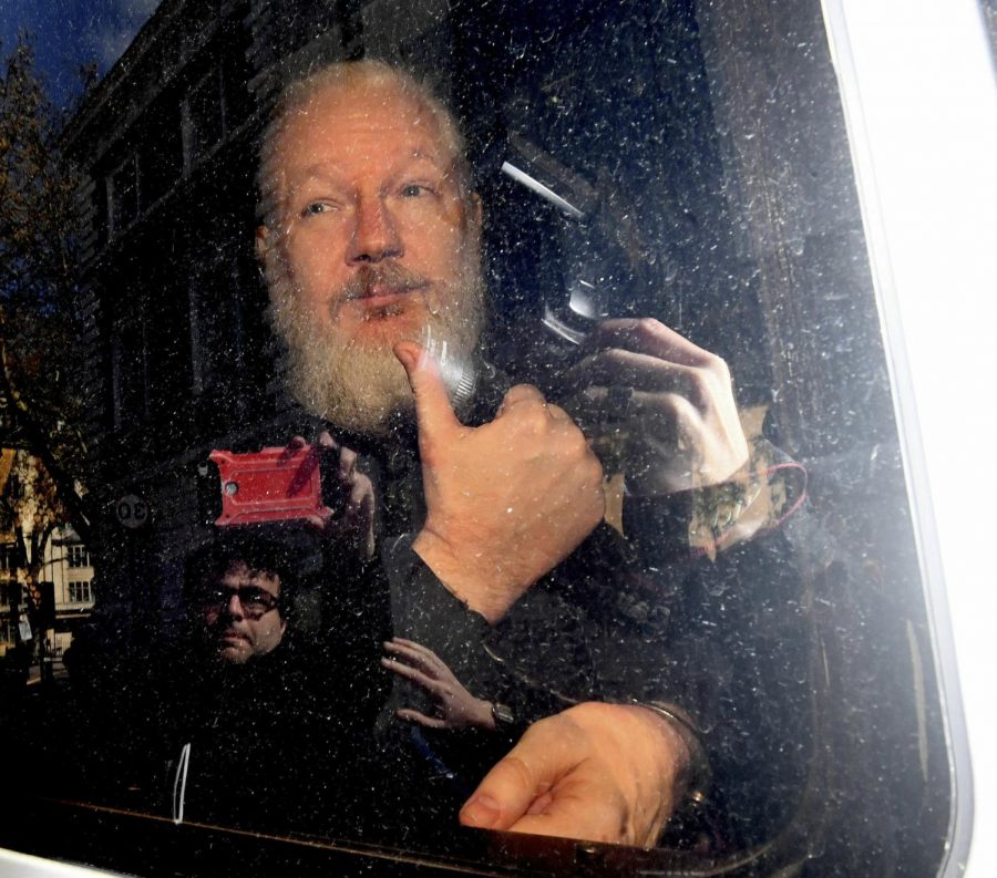 Julian Assange gestures as he arrives at Westminster Magistrates Court in London, after the WikiLeaks founder was arrested by officers from the Metropolitan Police and taken into custody Thursday April 11, 2019. Police in London arrested WikiLeaks founder Assange at the Ecuadorean embassy Thursday, April 11, 2019 for failing to surrender to the court in 2012, shortly after the South American nation revoked his asylum.