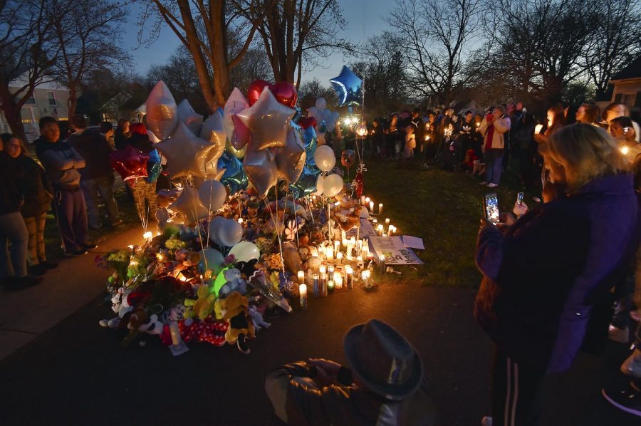 In this Wednesday, April 24, 2019 photo, community members in Crystal lake, Ill. hold a vigil in memory of 5-year-old Andrew AJ Freund. Authorities searching for the missing Illinois boy who had lived in deplorable conditions dug up his body Wednesday and charged his parents with murder, sadly declaring that the youngster would no longer have to suffer.