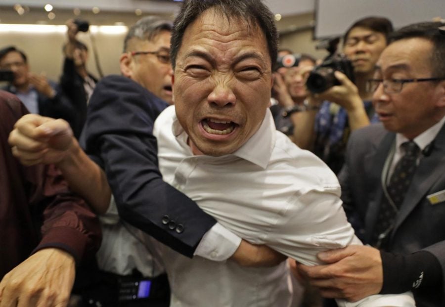 Pro-democracy lawmaker Wu Chi-wai is held by security guards at Legislative Council May 11.