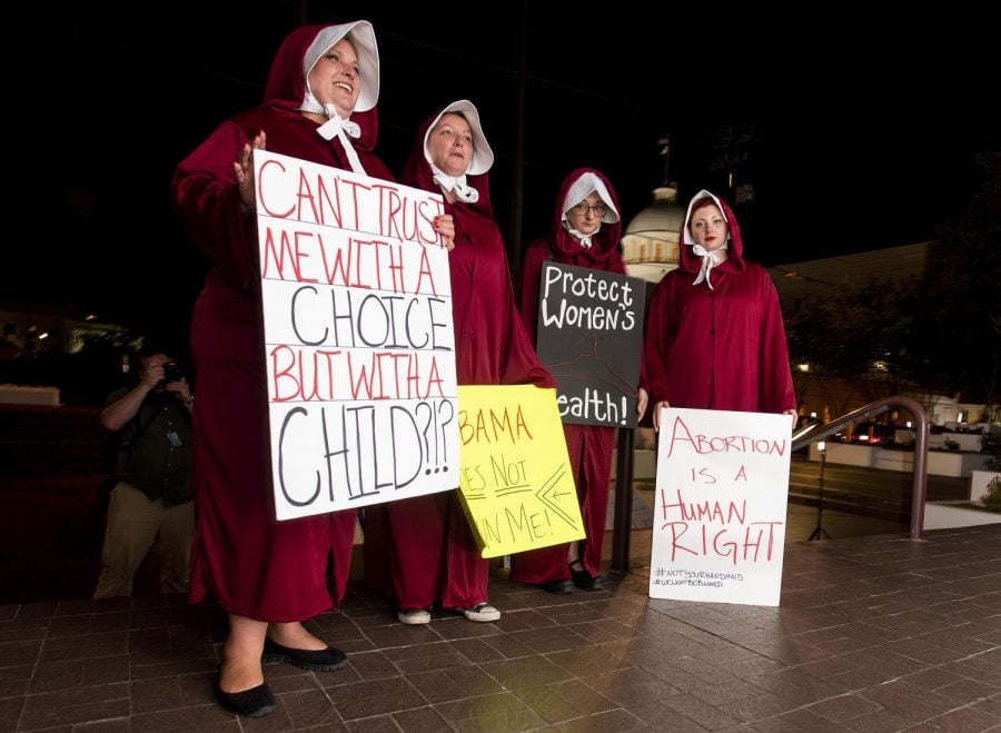 Protesters%2C+dressed+as+handmaids%2C+from+left%2C+Bianca+Cameron-Schwiesow%2C+Kari+Crowe%2C+Allie+Curlette+and+Margeaux+Hartline%2C+wait+outside+of+the+Alabama+statehouse+after+a+ban+on+nearly+all+abortions+passed+the+senate+in+Montgomery%2C+Ala.%2C+on+Tuesday%2C+May+14%2C+2019.+The+measure+now+goes+to+Gov.+Kay+Ivey%2C+who+has+not+said+whether+she+supports+the+measure.