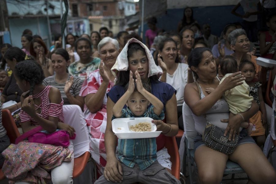 Women watch mariachis musicians perform during a Mother's Day block party in Caracas, Venezuela, late Sunday, May 19, 2019. Although Mother's Day was officially celebrated the previous weekend, people in the Petare area organized the neighborhood party to celebrate the mothers of their community.