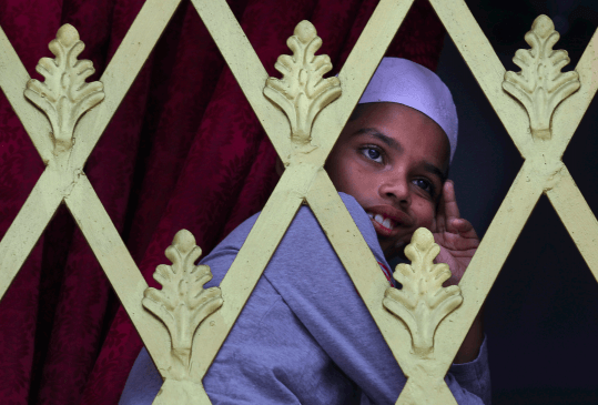 In this Friday, April 26, 2019 file photo, a Sri Lankan Muslim boy looks out from the window of a Mosque before Friday prayers in Colombo, Sri Lanka. Authorities had told Muslims to pray at home rather than attend communal Friday prayers that are the most important religious service for the faithful.