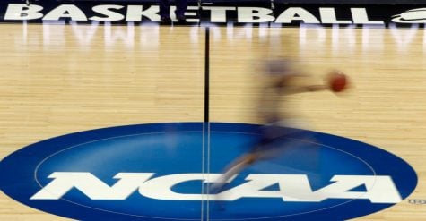 In this March 14, 2012, file photo, a player runs across the NCAA logo during practice in Pittsburgh.
