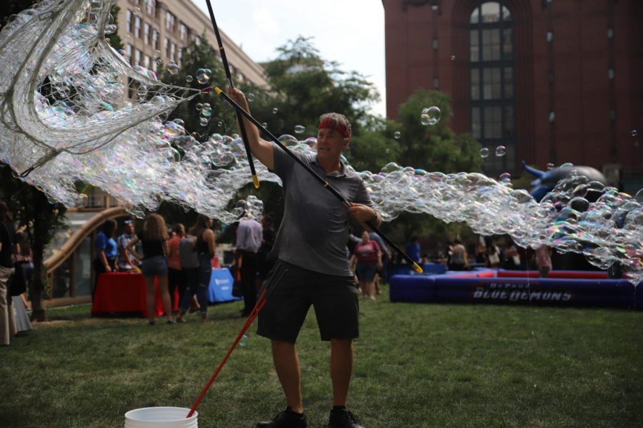 Scott Ingerson blows a giant bubble during the Loop Block Party held at Pritzker Park on Wednesday from 2-5 p.m. The Loop Block Party is one of the numerous free events during Welcome Week 2019.  Welcome Week also now includes an event at Wintrust Arena for incoming freshman.  