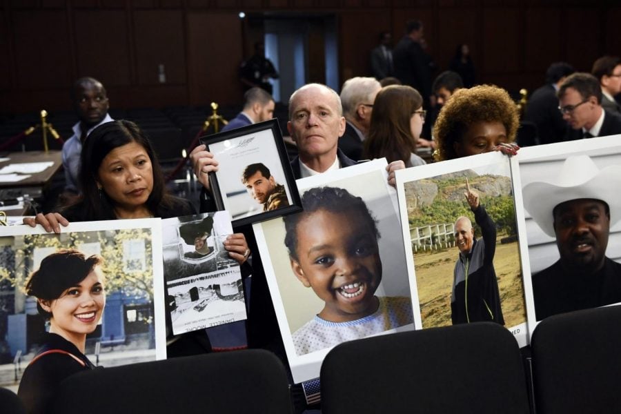 People holding photos of those lost in Ethiopian Airlines Flight 302 and Lion Air Flight 610 wait for the start of a Senate Committee on Commerce, Science, and Transportation hearing on Capitol Hill in Washington, Tuesday, Oct. 29, 2019, the Boeing 737 Max.