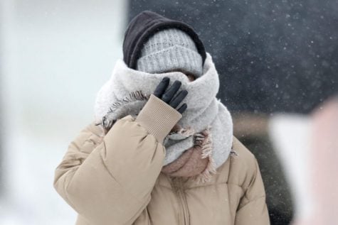 A woman walking the half mile from the Chicago Aquarium to the Adler Planetarium braces in a stiff wind and blowing snow off Lake Michigan, Monday, Nov. 11, 2019, in Chicago.