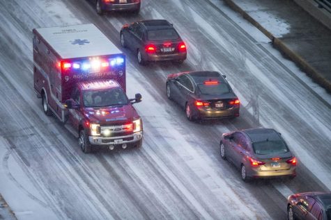 Snow falls as traffic moves slowly along State Street ahead of the Jeff Dunham comedy show at the BMO Harris Bank Center Saturday, Jan. 11, 2020, in downtown Rockford, Ill.