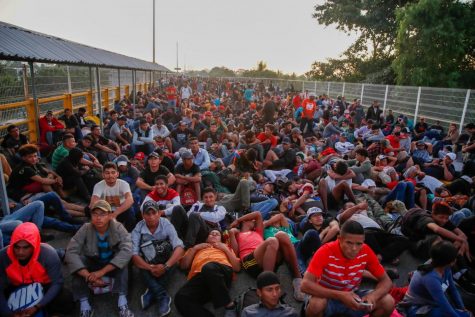 Migrantes hondureños esperan en el puente, el cruce fronterizo legal, que cruza el río Suchiate en Tecun Uman, en la frontera de Guatemala con México, al amanecer del lunes 20 de enero de 2020.