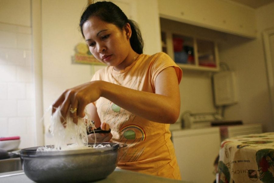In this Nov. 21, 2007, photo, Elizabeth Keathley, a Philippine citizen in the U.S. on a marriage visa, cuts rice noodles as she prepares a traditional Filipino dish for dinner in Bloomington, Ill. She applied for a driver’s license and was sent a voting registration card. She voted in 2006. In processing her green card, immigration authorities discovered she had voted, and she was ordered removed. However, judges determined she did not falsely represent herself, allowing her to stay.