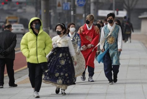 Visitors wearing face masks walk near the Gwanghwamun, the main gate of the 14th-century Gyeongbok Palace, and one of South Korea's well-known landmarks, in Seoul, South Korea, Saturday, Feb. 22, 2020. South Korea's Vice Health Minister Kim Gang-lip says the outbreak has entered a serious new phase but expressed cautious optimism that it can be contained to the region surrounding Daegu, where the first case was reported on Tuesday.