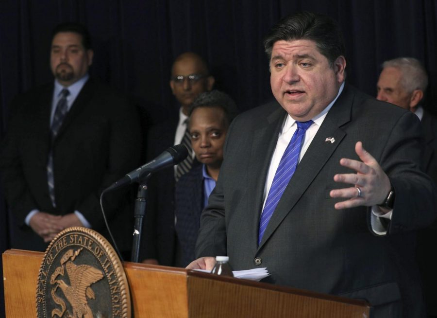 Illinois Gov. J.B. Pritzker, foreground, along with Chicago Mayor Lori Lightfoot, third from left, and public health officials provide updated public guidance around the coronavirus, during a press conference at the Thompson Center, Friday, Feb. 28, 2020, in Chicago.