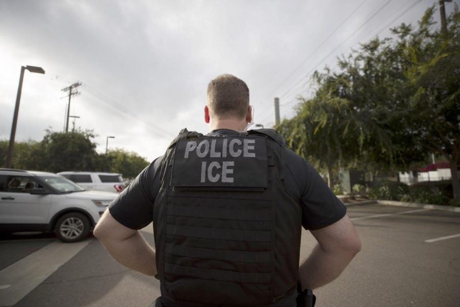 In this July 8, 2019, file photo, a U.S. Immigration and Customs Enforcement (ICE) officer looks on during an operation in Escondido, Calif. 