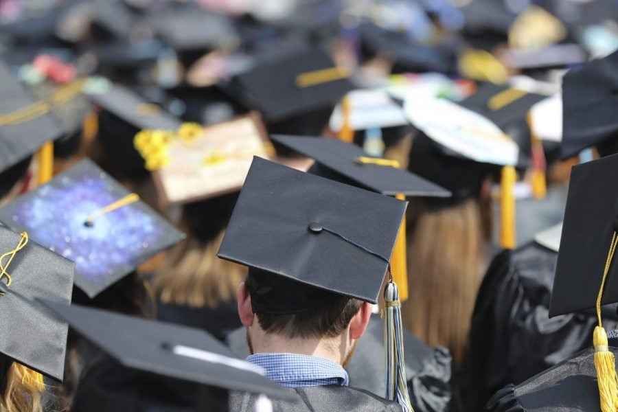 FILE- In this May 5, 2018, file photo, students attend the University of Toledo commencement ceremony in Toledo, Ohio. Colleges across the U.S. have begun cancelling and curtailing spring graduation events amid fears that the new coronavirus will not have subsided before the stretch of April and May when schools typically invite thousands of visitors to campus to honor graduating seniors.