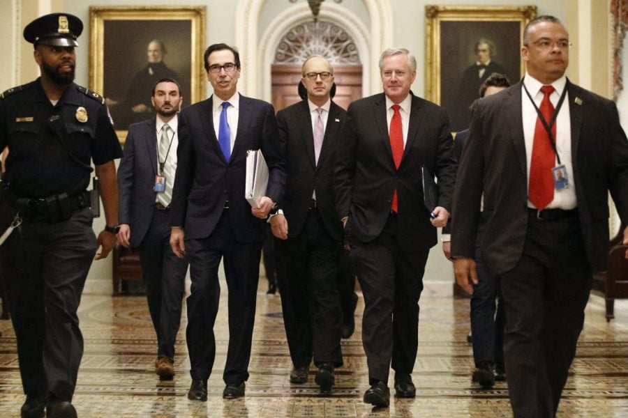 Treasury Secretary Steven Mnuchin, left, accompanied by White House Legislative Affairs Director Eric Ueland and acting White House chief of staff Mark Meadows, walks to the offices of Senate Majority Leader Mitch McConnell of Ky. on Capitol Hill in Washington, Tuesday, March 24, 2020.