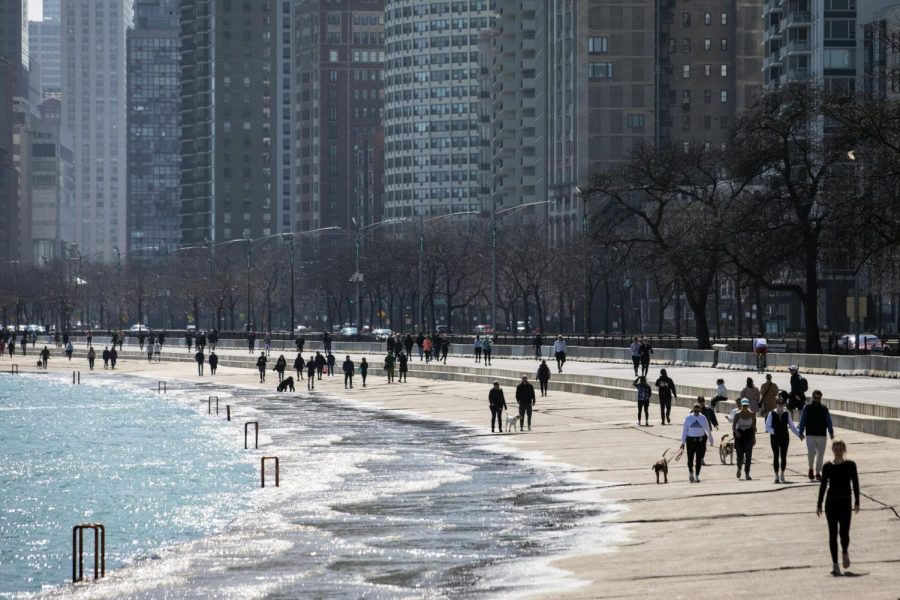 Residents enjoy the warm weather with a stroll along the Lakefront Trail near Oak Street Beach, Wednesday afternoon, March 25, 2020, in Chicago, despite a stay-at-home order from Illinois Gov. J.B. Pritzker during the coronavirus pandemic. The new coronavirus causes mild or moderate symptoms for most people, but for some, especially older adults and people with existing health problems, it can cause more severe illness or death.