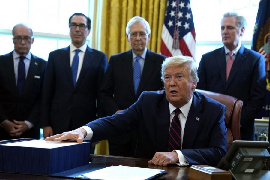 President Donald Trump speaks before he signs the coronavirus stimulus relief package in the Oval Office at the White House, Friday, March 27, 2020, in Washington. Listening are from left, Larry Kudlow, White House chief economic adviser, Treasury Secretary Steven Mnuchin, Senate Majority Leader Mitch McConnell, R-Ky., and House Minority Leader Kevin McCarty of Calif.