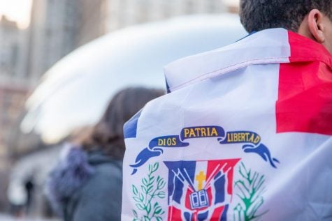A man wears a Dominican Republic flag in front of the Bean in Chicago. A group gathered in front of the bean on the Dominican Republics independence day, the group was protesting what they consider unfair elections in their home country.