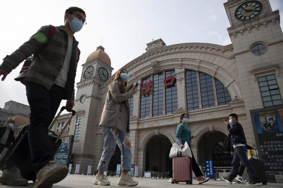 Travelers with their luggage walk past the Hankou railway station on the eve of its resuming outbound traffic in Wuhan in central China's Hubei province on Tuesday, April 7, 2020. Starting Wednesday, residents of Wuhan will be allowed to once again travel in and out of the sprawling city where the coronavirus pandemic began, ending an 11-week lockdown.

