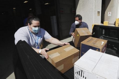 Christina Caldwell, left, of Henry Ford Population Health helps unload supplies with Matt Thatcher, who donated them from the Detroit Golf Club, Wednesday, April 8, 2020, in Detroit. The hospital is also in need of gowns and other PPE items and hopes more donations will be coming in from others to help during the coronavirus pandemic.