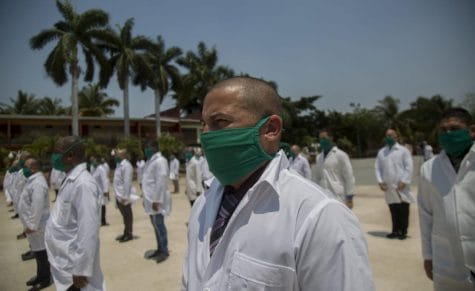 Los médicos cubanos se ponen en fila durante una ceremonia de despedida mientras se preparan para partir a Italia para ayudar con la nueva pandemia de coronavirus, en La Habana, Cuba.