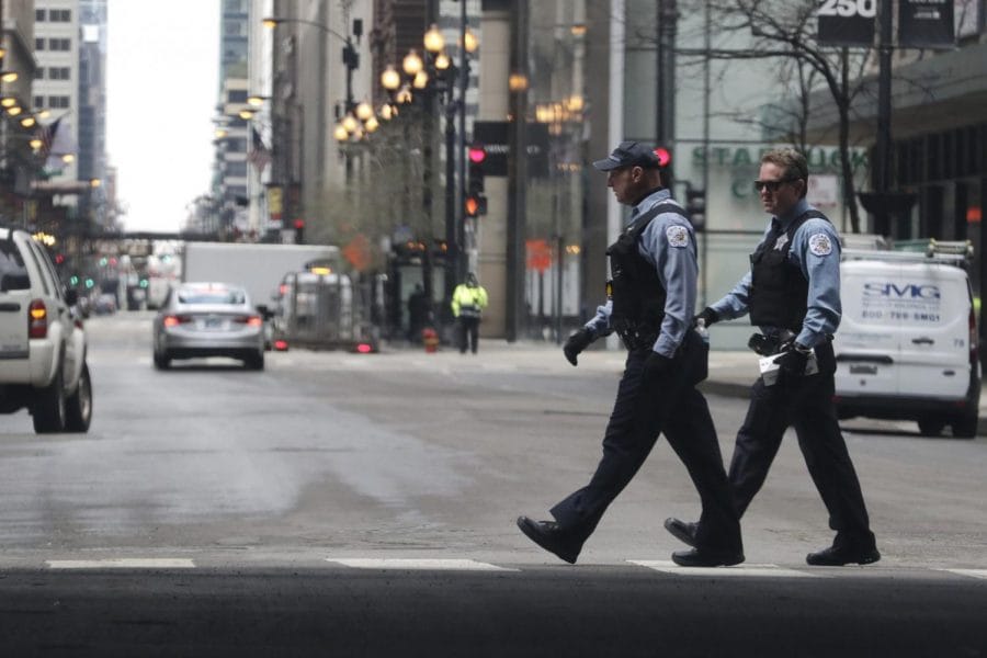 Chicago Police officers cross the street in downtown Chicago, Wednesday, April 22, 2020. 