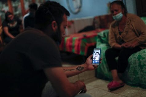 El nieto Gustavo Briseno Pinera comparte una videollamada con una nieta que llora, que vive cerca pero solo pudo estar presente por teléfono debido a la pandemia de coronavirus, ya que los miembros de la familia lloran a Manuel Briseno Espino, de 78 años, quien murió por complicaciones debido a COVID-19.