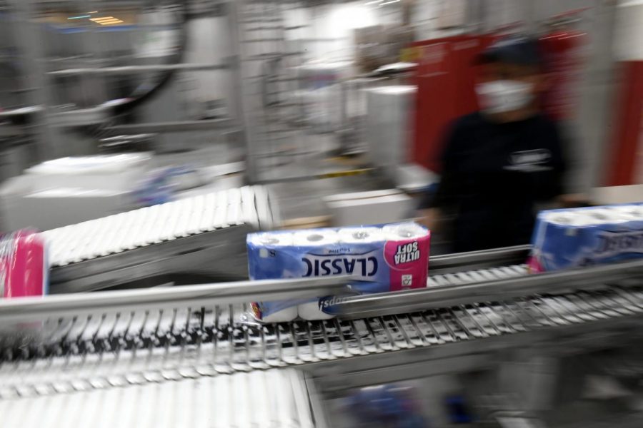 A worker checks the toilet paper rolls on a conveyor belt at a plant of Vajda-Papir Ltd in Budapest, Hungary, Friday, April 17, 2020. 