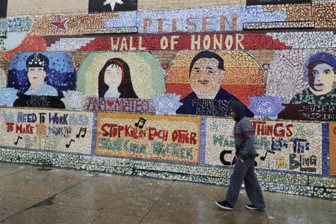 Un hombre camina en la acera junto a un mural, durante la pandemia COVID-19 en el barrio de Pilsen de Chicago.