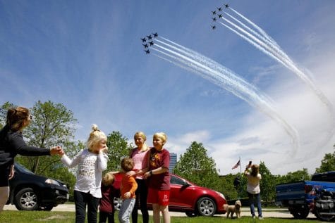 The Ferry family, from Chantilly, Va., who were in the middle of taking a family photograph, are surprised by a second fly over by the Blue Angels and Thunderbirds, in a