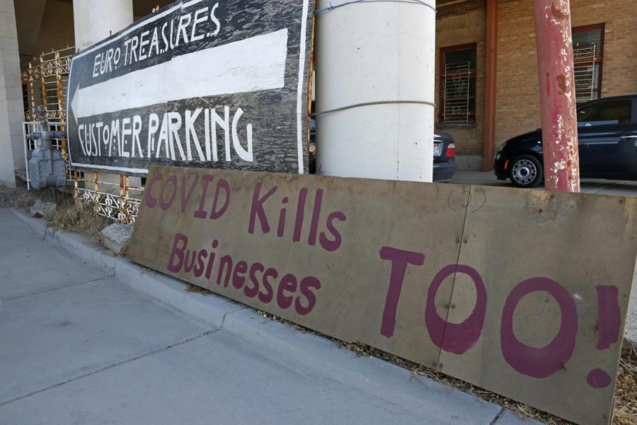 A Covid kills businesses too sign is shown outside Euro Treasures Antiques Friday, May 8, 2020, in Salt Lake City. Scott Evans is closing his art and antique store after 40 years. With a drastic drop in customers due to COVID-19 concerns and shelter-in-place orders, Evans says it was no longer cost effective to stay open.