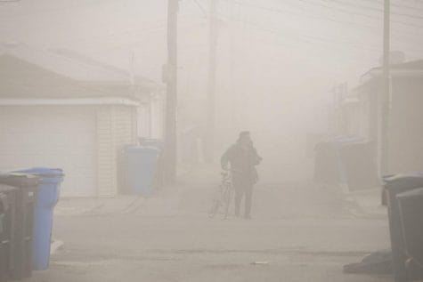 En esta foto del 11 de abril de 2020, un fotógrafo con una bicicleta camina a través de la nube de polvo que desciende a través del vecindario de La Villita, después de que la pila de humo de la Estación Generadora Crawford fue implosionada en Chicago.Cincuenta años después de que el primer Día de la Tierra ayudara a estimular el activismo sobre la contaminación del aire y el agua y la desaparición de plantas y animales, las mejoras significativas son innegables, pero persisten desafíos monumentales. Las comunidades minoritarias sufren desproporcionadamente la contaminación continua. La deforestación, la pérdida de hábitat y la sobrepesca han causado estragos en la biodiversidad mundial. Y la amenaza existencial del cambio climático se avecina en grande.