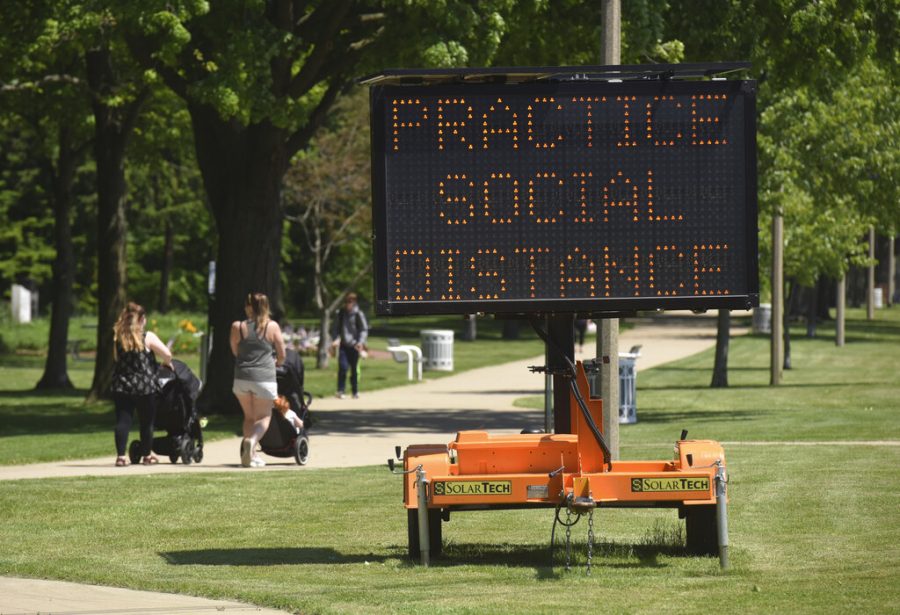 A sign along the bluff in downtown St. Joseph, Mich., encourages social distancing Tuesday, June 2, 2020, as the state slowly continues to open after being shut down for months due to the COVID-19 pandemic.(Don Campbell/The Herald-Palladium via AP)