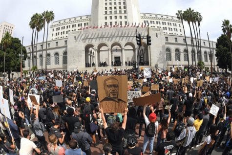 In this photo taken with a wide angle lens, demonstrators stand in front of Los Angeles City Hall during a protest over the death of George Floyd Tuesday, June 2, 2020, in Los Angeles. Floyd died in police custody on Memorial Day in Minneapolis.
