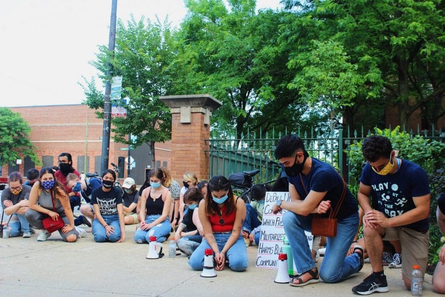 Protesters take a knee near the Lincoln Park Quad.