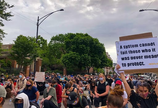 At a June protest calling for DePaul to divest from the Chicago Police Department, protesters take a knee on Fullerton Ave for eight minutes and 45 seconds in honor of George Floyd.