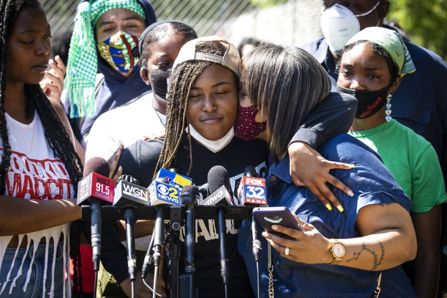 Miracle Boyd, 18, an activist with GoodKids MadCity, hugs a supporter as she speaks during a press conference in front of a statue of President George Washington near East 51st Street and South King Drive, describing a recent violent encounter she had with Chicago Police, Monday morning, July 20, 2020. Boyd was participating in a Friday evening protest against a statue of Christopher Columbus in Grant Park, when she alleges she had several teeth knocked out by a Chicago Police officer. (Ashlee Rezin Garcia/Chicago Sun-Times via AP)